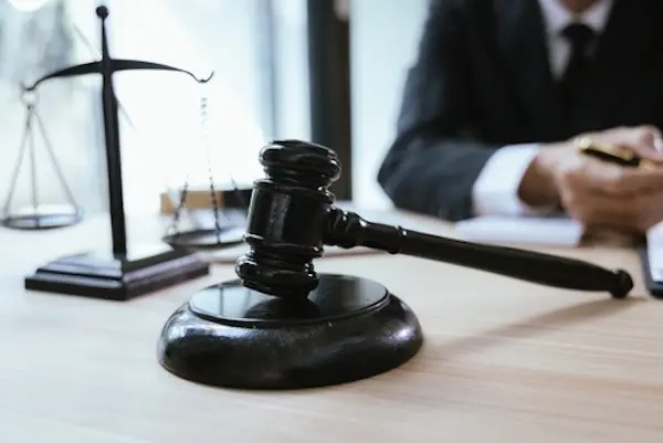 Vehicle property damage lawyer reviewing paperwork at desk with gavel.