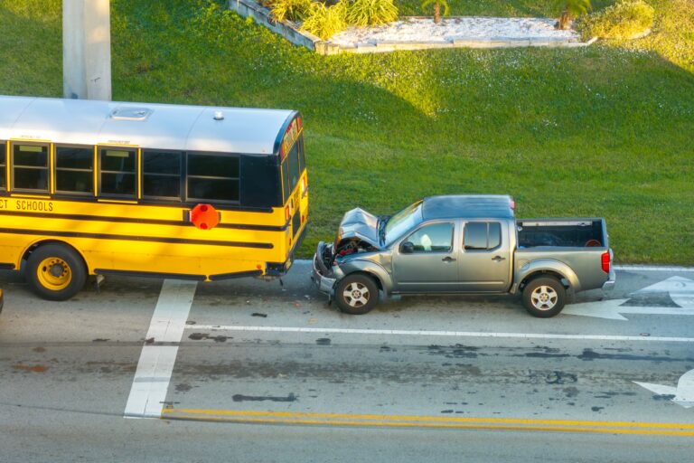 A yellow school bus that collided with a gray pickup truck is showing severe front-end damage from car accidents at the intersection in North Carolina.