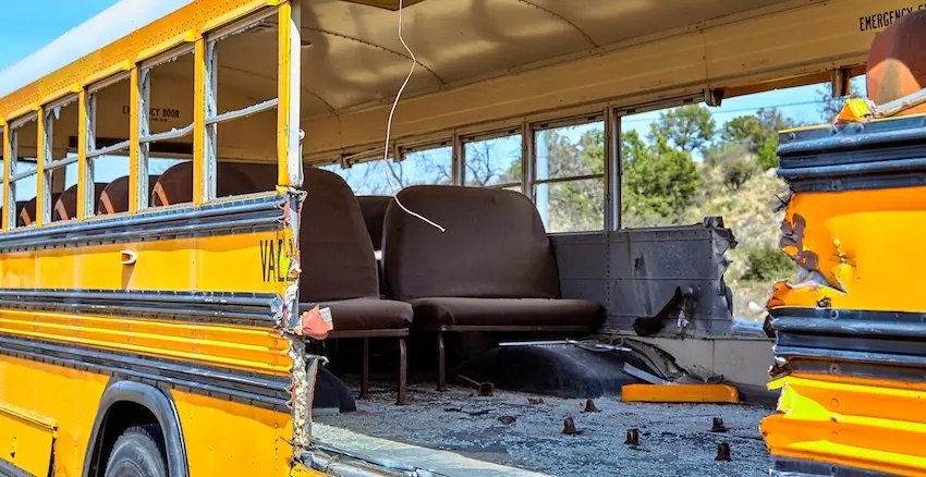A heavily damaged yellow school bus interior with torn seats and debris after serious car accidents in North Carolina.