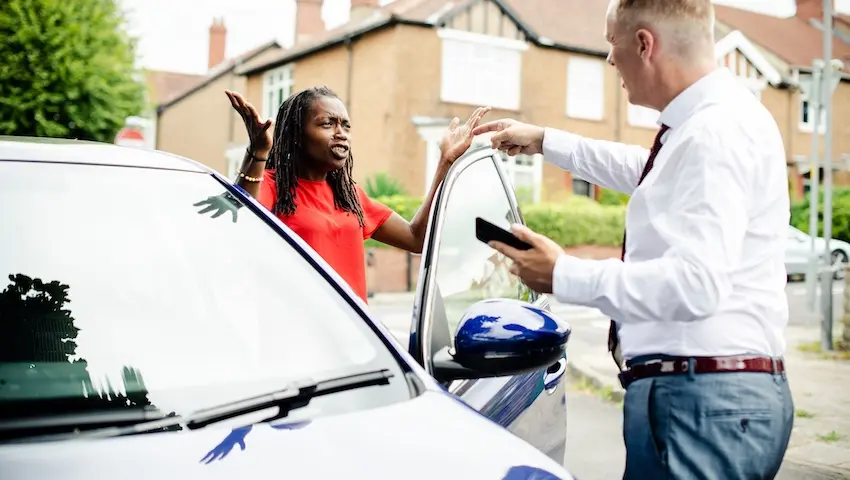 An insurance adjuster is documenting vehicle damage with the woman after minor car accidents for claim assessment and repairs in North Carolina.