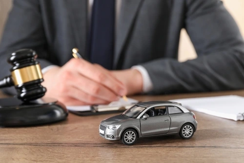 Rideshare accident lawyer working at a desk with a toy car