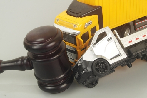 Two toy trucks running into a toy gavel representing a truck accident case.