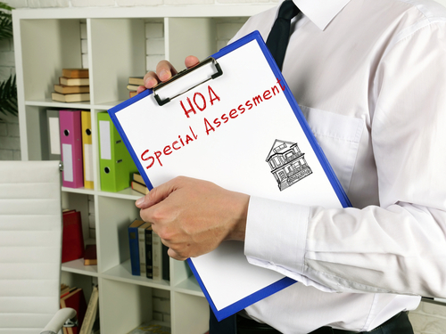 real estate lawyer with a clip board going over HOA special assessments with the team at The Law Office of Mark Farbman.